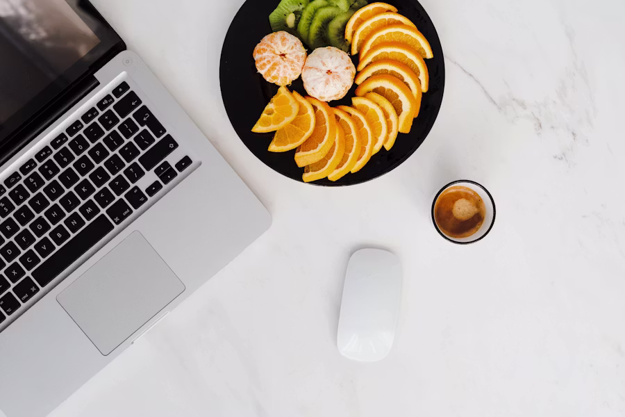 Laptop, coffee cup, and breakfast on a marble counter — editorial workspace